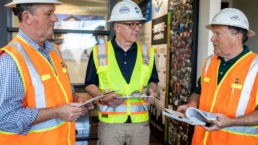 Three Employees Dress in Construction Uniform Conversating